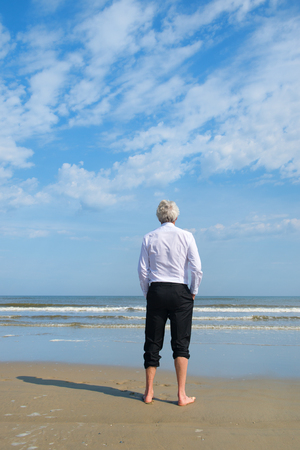 Business man in formal suit standing in the seaの写真素材