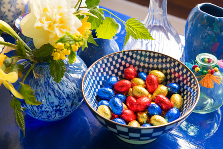 Blue still life with chocolate easter eggs and daffodilsの写真素材