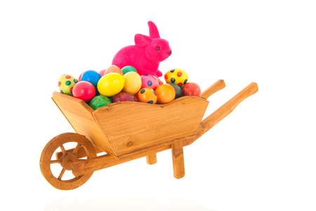 Wheelbarrow easter hare and eggs isolated over whiteの写真素材