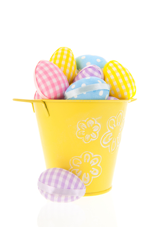 Full pastel colored easter eggs in bucket isolated over whiteの写真素材
