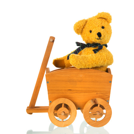Stuffed bear toy sitting in cart isolated over white backgroundの写真素材