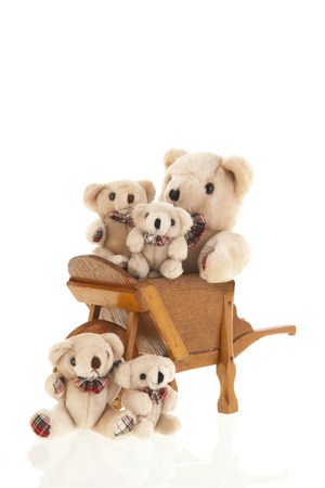 Vintage classic wooden wheel barrow full stuffed bears isolated over white backgroundの写真素材
