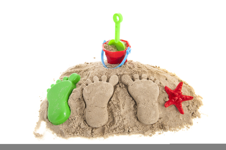 Feet prints and plastic toys at the beach isolated over white backgroundの写真素材
