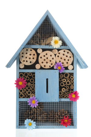Blue insect hotel with flowers isolated over whiteの写真素材