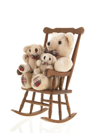 Classic rocking chair full with many stuffed bears isolated over white backgroundの写真素材