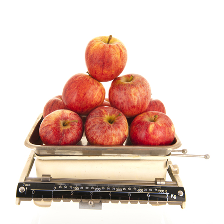 Kitchen weight scale fresh red apples isolated over whiteの写真素材