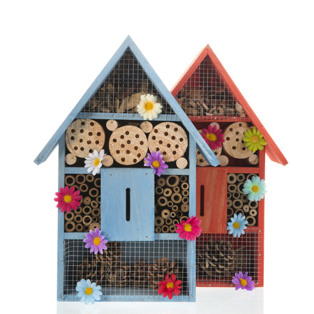 Two insect hotels with flowers isolated over whiteの写真素材