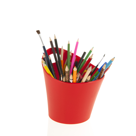 Red container full pencils and brushes isolated over whiteの写真素材