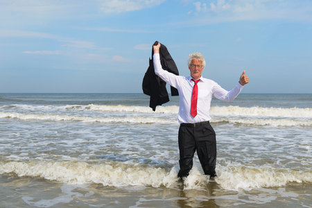 Business man in formal suit satisfied standing in the seaの写真素材