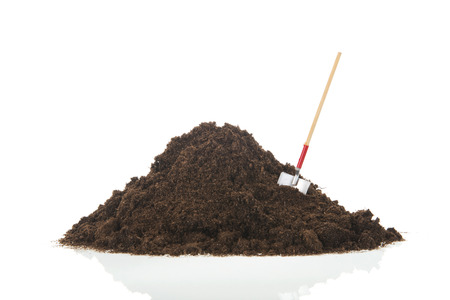 Black heap sand with shovel isolated on whiteの写真素材