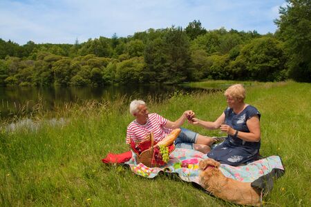 Elderly couple are having picnic in natureの写真素材