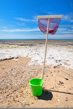 Beach with fishing net and bucket in Saint Marie en Re on island Ile de Reの写真素材