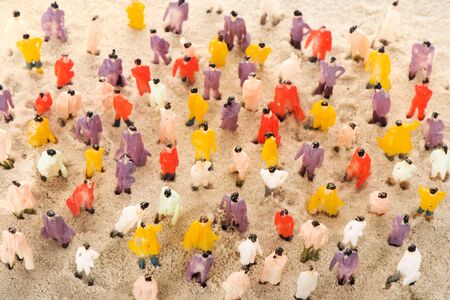 Crowd of many little figurines in sandの写真素材