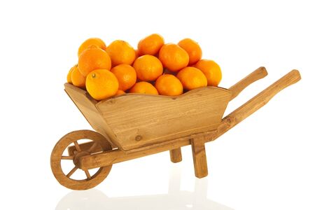 Wooden wheel barrow with mandarins isolated over white backgroundの写真素材