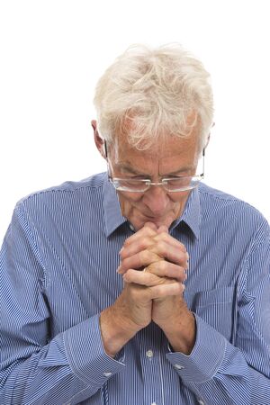 Portrait praying senior man isolated against white backgroundの写真素材