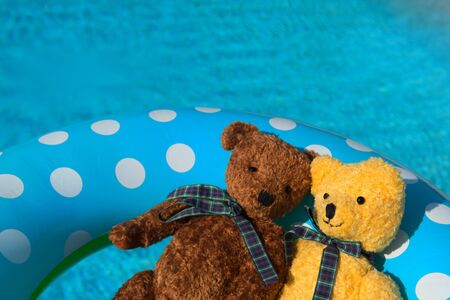 Two toy bears in inflatable toy in swimming poolの写真素材