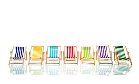 Row colorful beach deck chairs isolated over white backgroundの写真素材