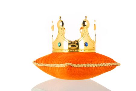 Orange royal velvet pillow with crown isolated over white backgroundの写真素材