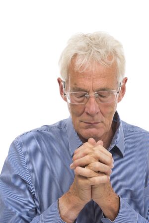 Portrait praying senior man isolated against white backgroundの写真素材