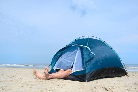 Single man sleeping in shelter at the beachの写真素材