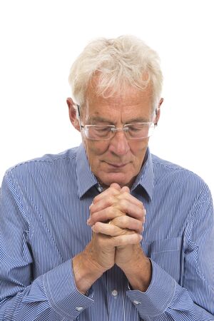 Portrait praying senior man isolated against white backgroundの写真素材