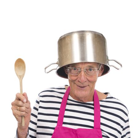 Senior houseman with pink apron and cooking pot isolated over white backgroundの写真素材