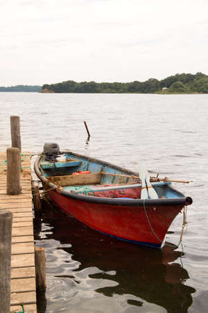 Red rowing boat in lake Urbino on French island Corsicaの写真素材