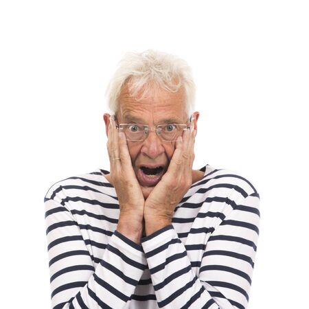 Scaring senior man with glasses isolated over white backgroundの写真素材