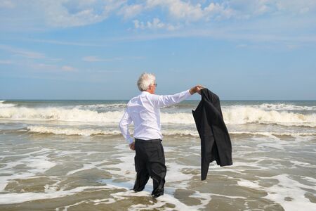 Business man in formal suit satisfied standing in the seaの写真素材
