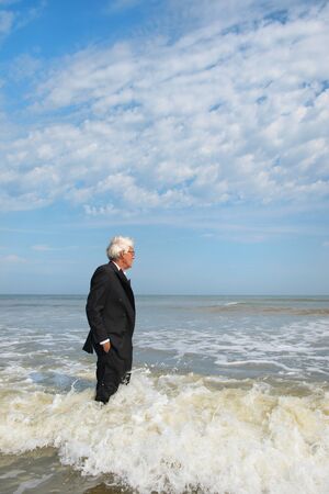 Business man in formal suit satisfied standing in the seaの写真素材