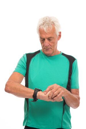 Portrait senior sport man checking time on watch against whiteの写真素材