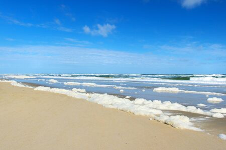 Landscape empty beach with sea foam surfs and waterの写真素材