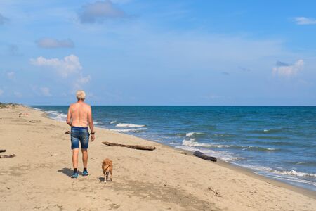 Man with his dog at the Corsican beachの写真素材