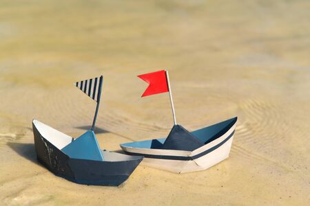 Blue paper boats floating on waterの写真素材