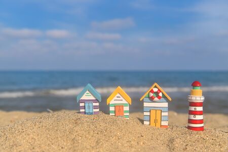 Miniature wooden huts and lighthouse at the beachの写真素材