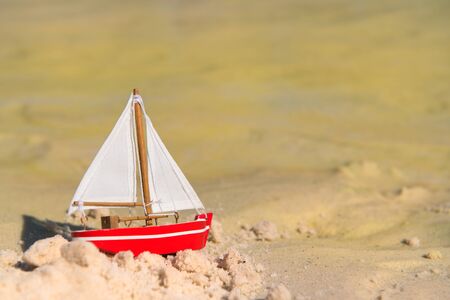 Red miniature boat at the beachの写真素材