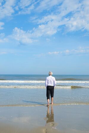 Business man in formal suit walking in the seaの写真素材