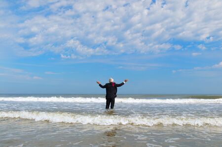 Business man in formal suit standing in the seaの写真素材