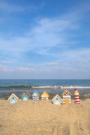 Miniature wooden huts and lighthouse at the beachの写真素材