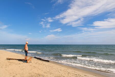 Man with his dog at the Corsican beachの写真素材