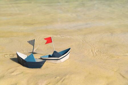 Blue paper boats floating on waterの写真素材