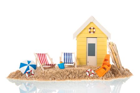 Beach chairs and yellow hut in sand isolated over white backgroundの写真素材
