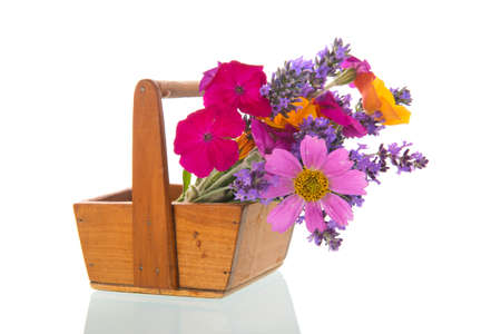 Colorful flower bouquet in wooden harvest basketの写真素材