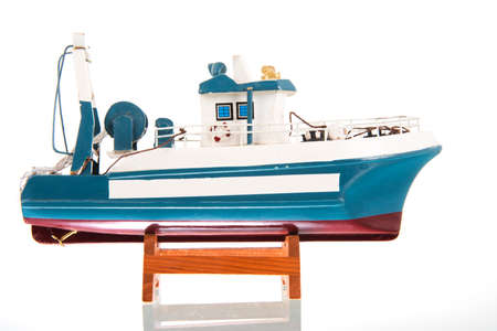 Miniature blue fishing trawler isolated over white backgroundの写真素材