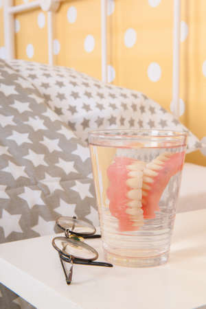 Bedroom old peoples home with false teeth and glassesの写真素材