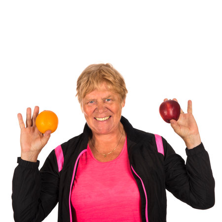 Senior woman with fresh fruit and sporting clothingの写真素材