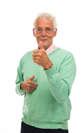 Senior man in green sweater thumbs up isolated over white backgroundの写真素材
