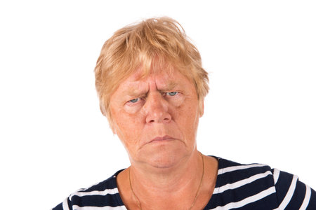 Portrait blonde senior woman angry on white backgroundの写真素材