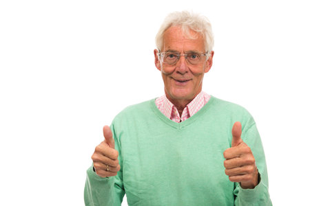 Senior man in green sweater thumbs up isolated over white backgroundの写真素材