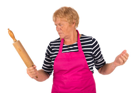 Very angry elder woman with pin roller isolated over white backgroundの写真素材